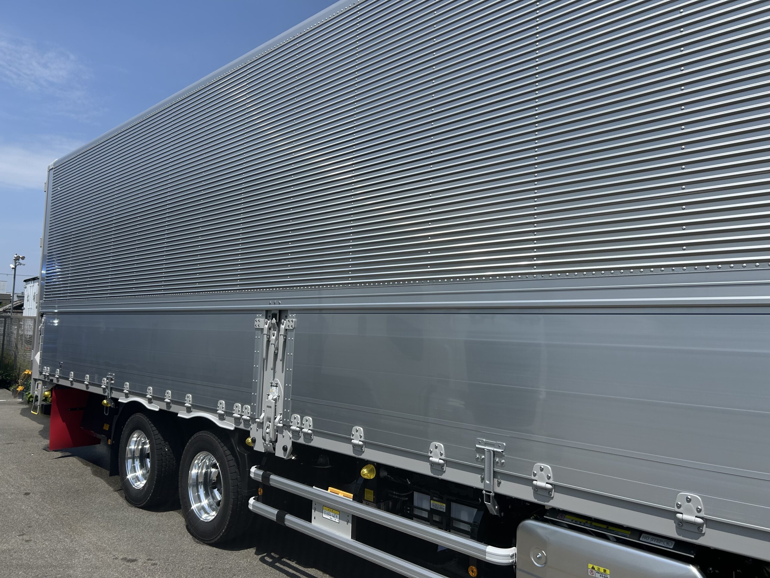 白い大型トラックのアルミバン側面コーティング施工対象