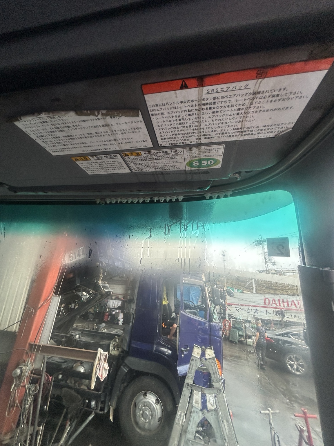 日野大型トラックのサンバイザーを洗浄中
