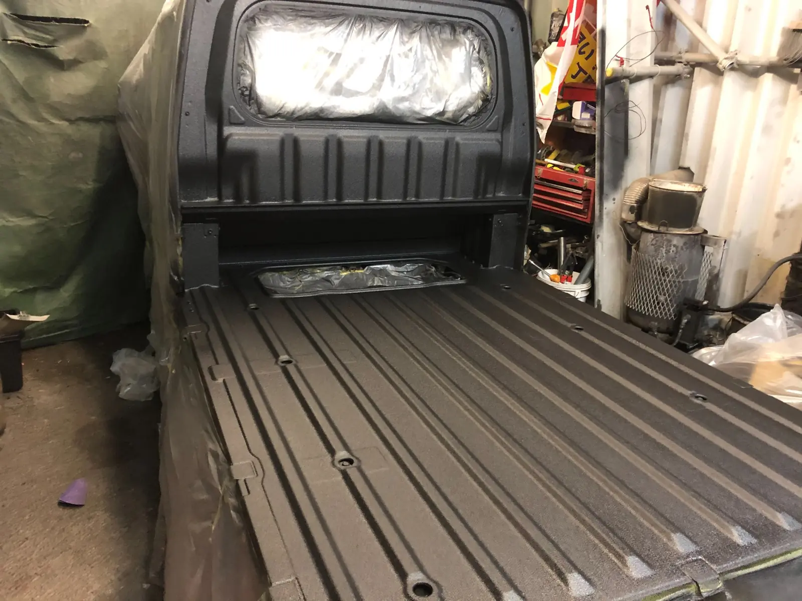 Black RAPTOR-coated Hijet Jumbo bed with masking over the rear window and access opening