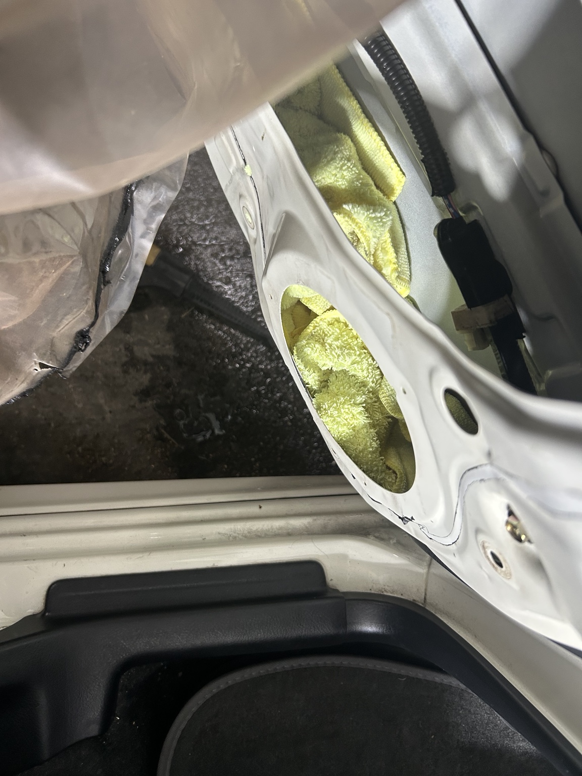 ドア内部の嘔吐クリーニングでスピーカー開口部から温めたタオルを使って汚れを拭き取る様子