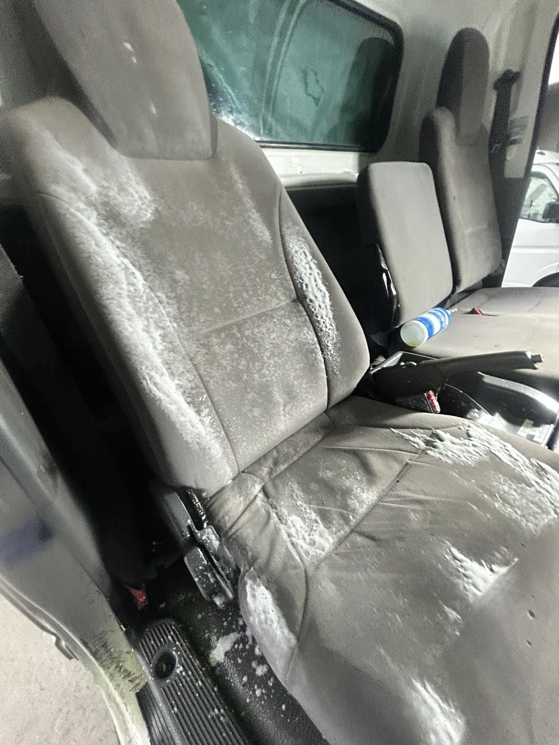 エルフの車内クリーニング中に運転席の背もたれと座面を泡洗浄している様子